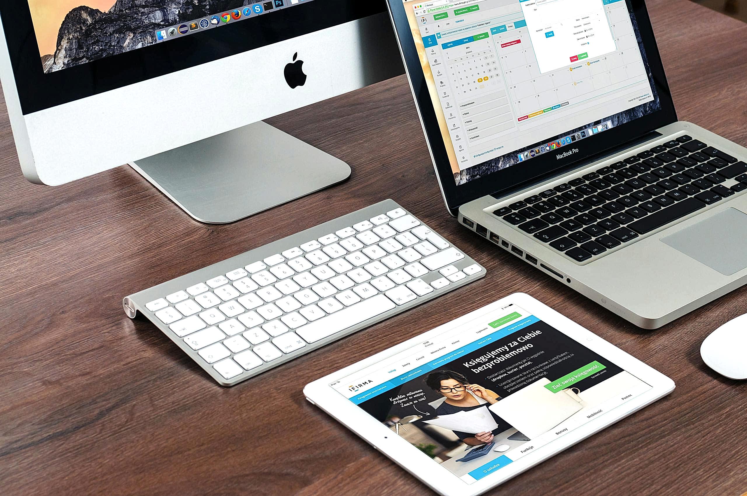 A sleek office desk setup featuring Apple devices: iMac, MacBook, and iPad. Ankara web tasarım ajansı
